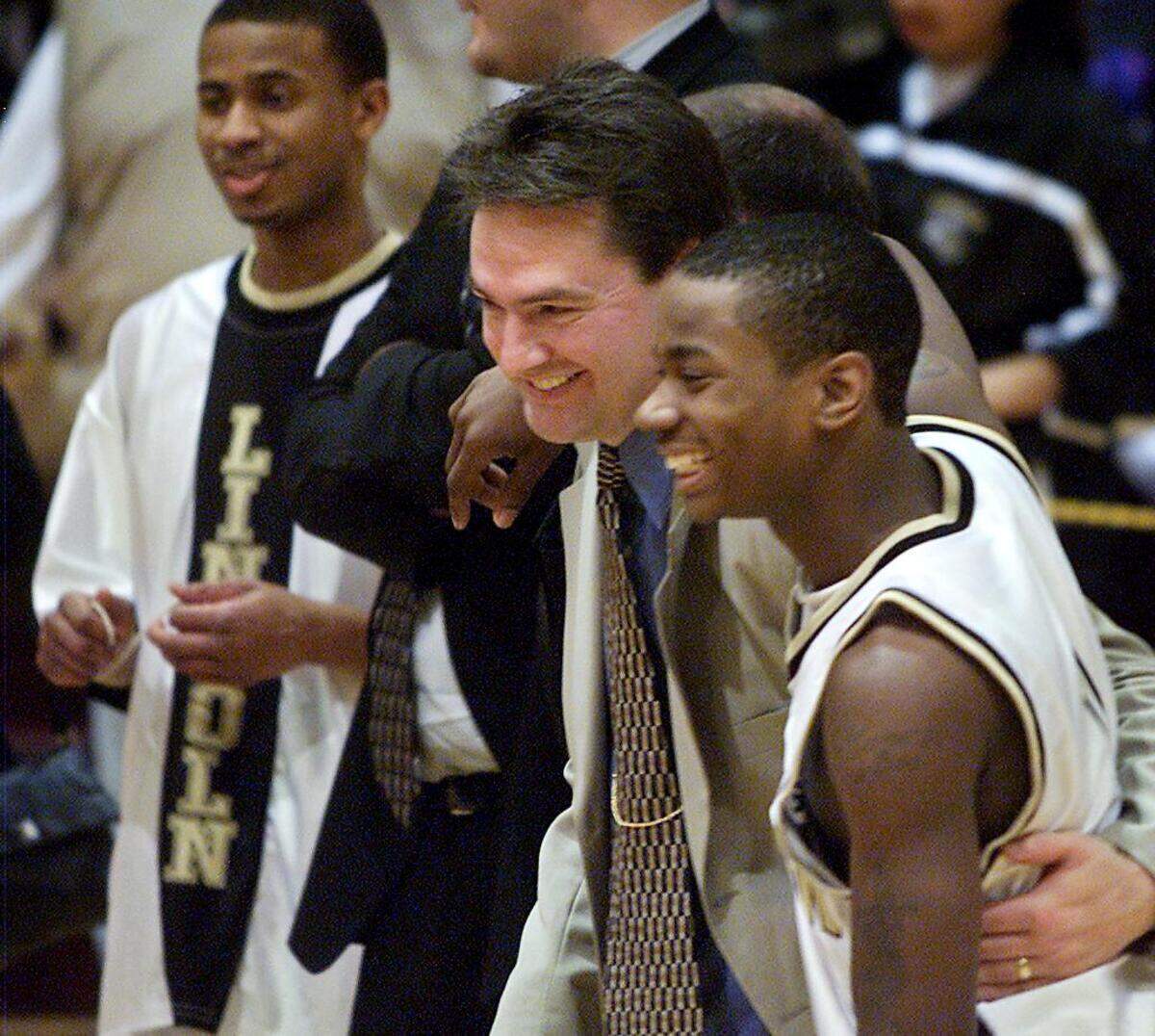 SLUG: ABES WIN DISTRICT 4A PHOTO TAKEN: Tacoma, Saturday, March 2, 2002 Lincoln head coach Tim Kelly gets a hug from guard Robert Crawford after the Abes captured the 4A WCD at UPS Saturday night. (Drew Perine/The News Tribune)