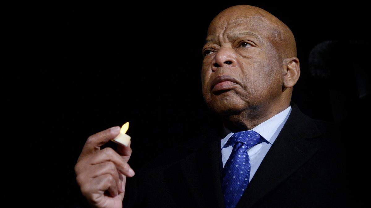 U.S. Rep. John Lewis (D-GA) holds a candle during an event to address President Donald Trump’s executive orders on January 30, 2017, in front of the Supreme Court in Washington, D.C.