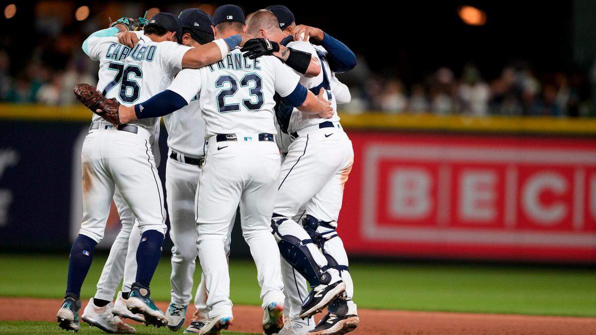The Seattle Mariners infield, including second baseman Jose Caballero (76) and catcher Tom Murphy (2), do a dance to celebrate a 6-2 win over the Boston Red Sox in a baseball game, Monday, July 31, 2023, in Seattle. (AP Photo/Lindsey Wasson)