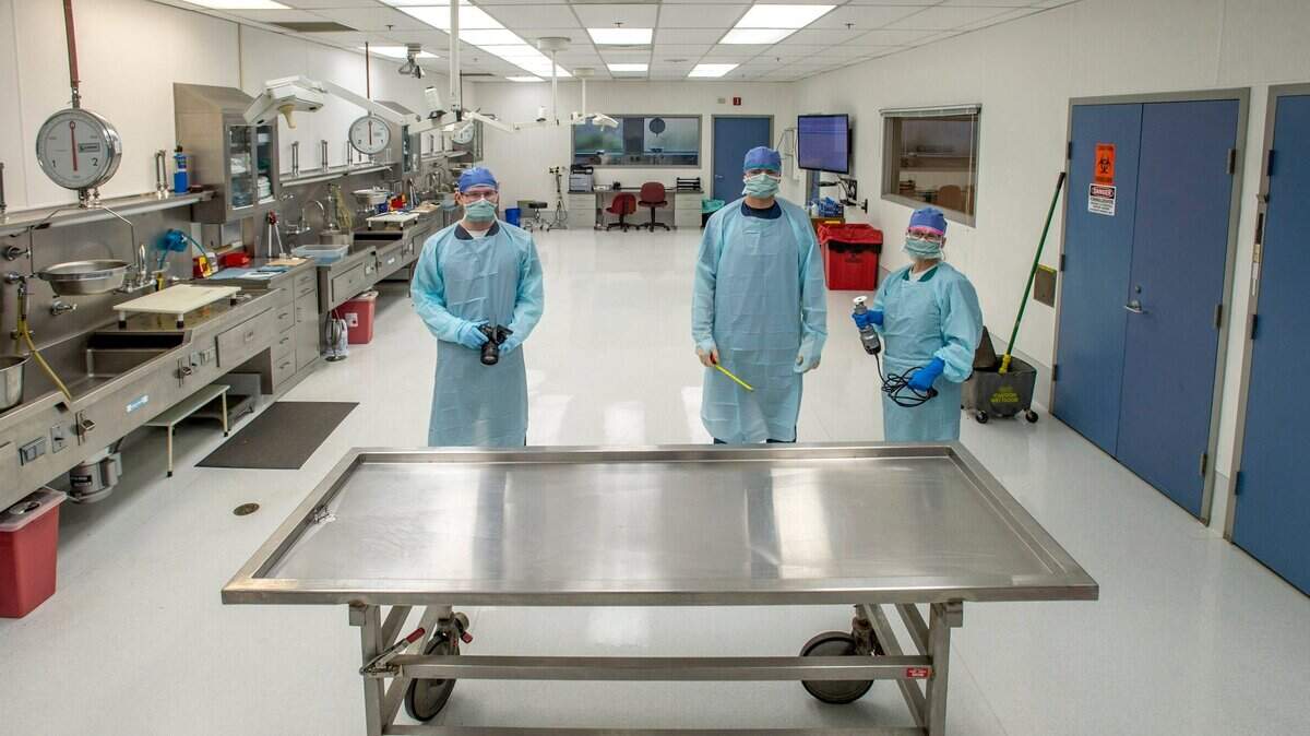 Staff members are shown in the autopsy room at the Pierce County medical examiner’s offices. The 17-member staff will soon be supplemented by a “transport agent” to help move dead bodies.