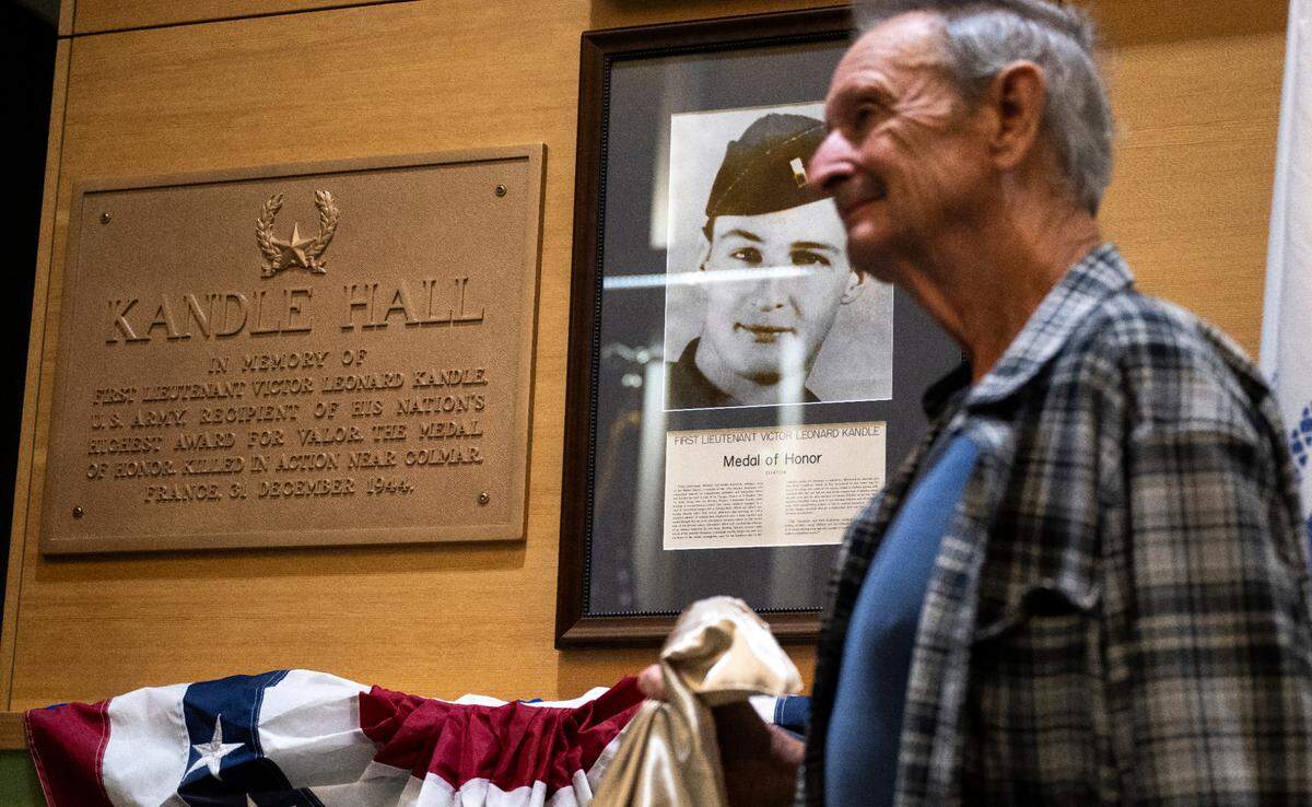 Terry Kandle unveils a restored plaque and photo of his father, World War II soldier Lt. Victor Kandle, during a dedication ceremony to rename the lobby in honor of his father at Puyallup City Hall, on Tuesday, Nov. 12, 2024 in Puyallup.
