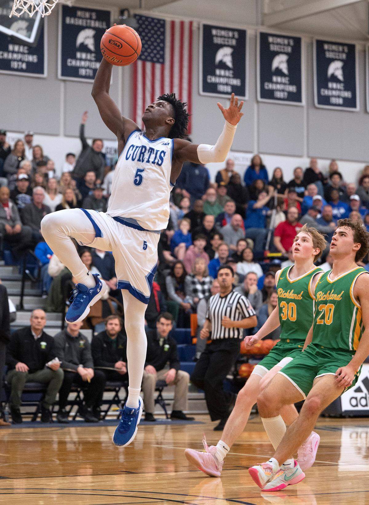 Curtis’s Zoom Diallo goes up for a breakaway dunk in front of Richland defenders Brock Streufert (30) and Jase Vopalensky during Friday night’s 4A boys state regional playoff game at Tacoma Community College in Tacoma, Washington, on Feb. 24, 2023. Curtis won the game, 64-55.