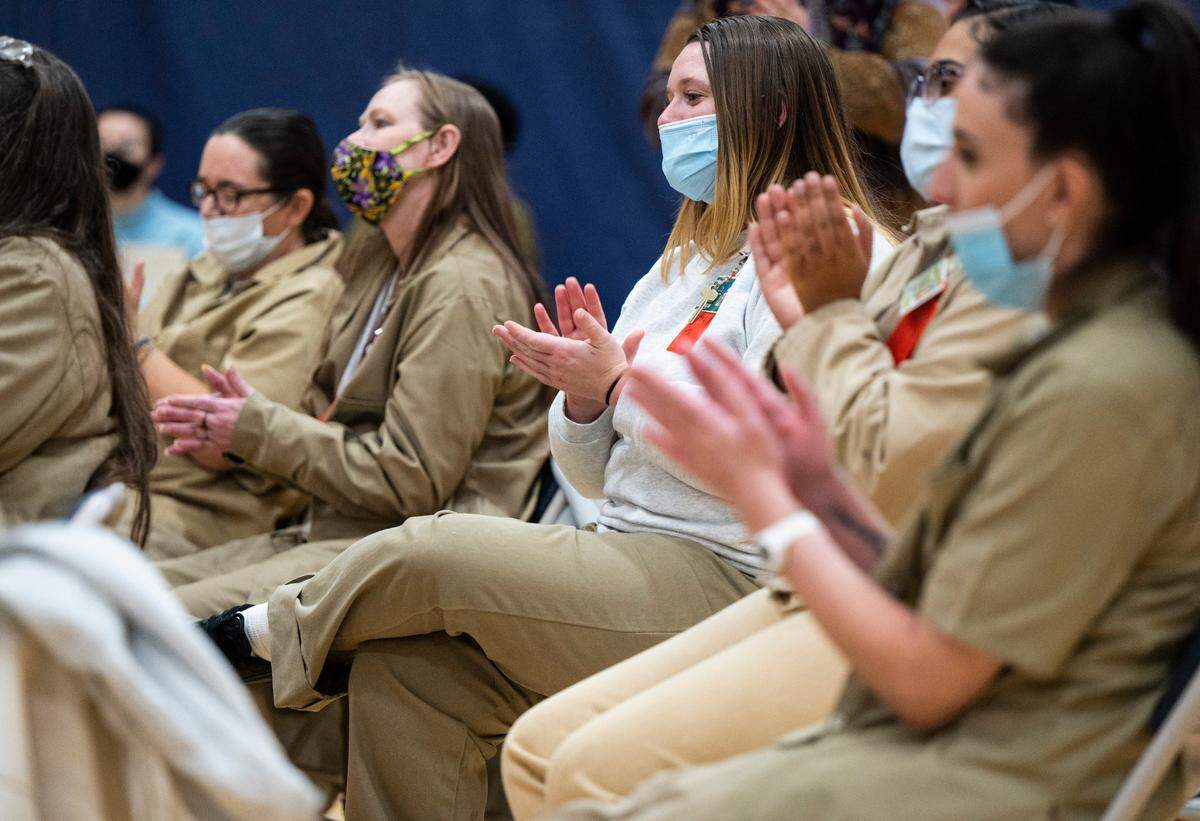 Laycee David, center, an inmate at the Washington Corrections Center for Women, claps after members of the Seattle Symphony finish a live performance in the center’s gymnasium near Gig Harbor, Wash. on Dec. 6, 2022.