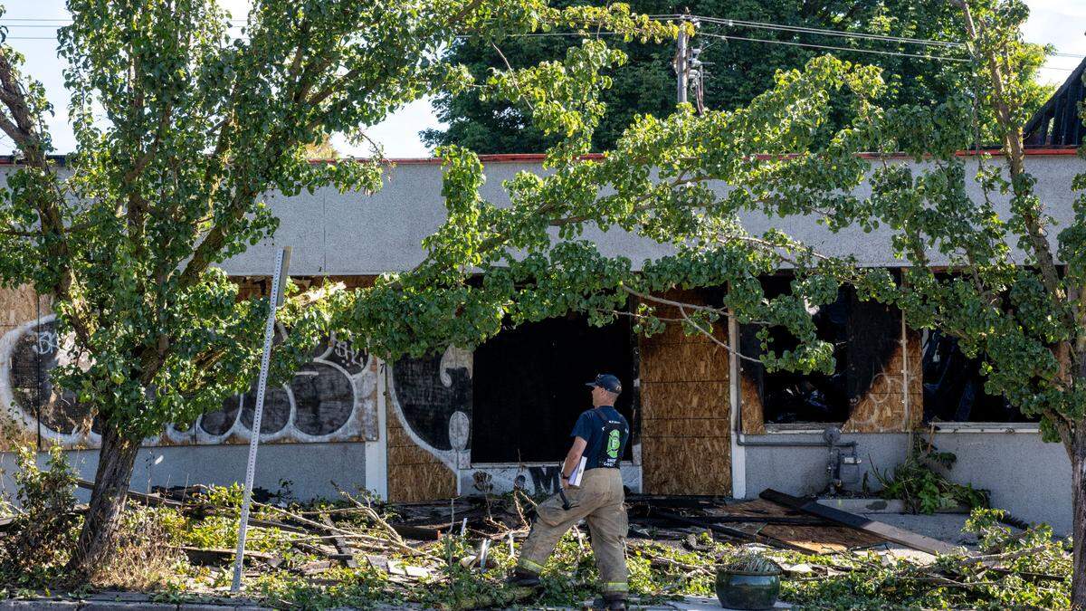 A Tacoma Fire Department fire inspector stands in front of a building in the Stadium District that caught fire the previous night on Friday, Aug. 4, 2023, in Tacoma.