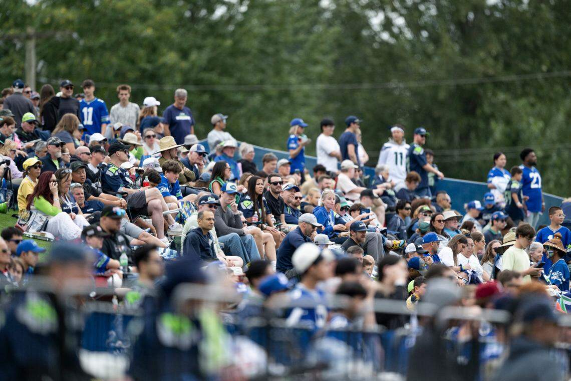 Fans watch as Seattle Seahawks players run drills during training camp at Virginia Mason Athletic Center on Friday, July 25, 2025, in Renton, Wash.