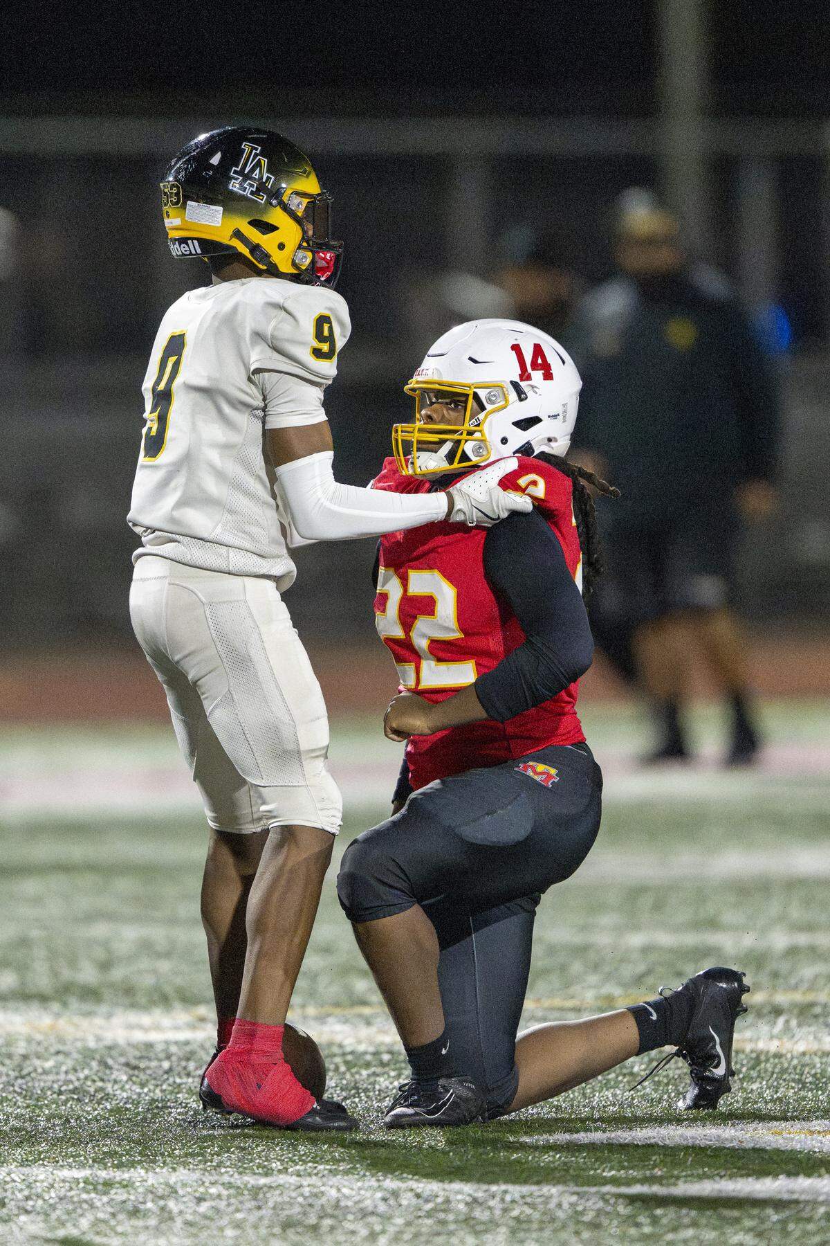 Lincoln defensive back Ramon Jones (9) helps Mount Tahoma running back Keshawn Hines (22) up by the shoulder pads on Saturday, Nov. 22, 2025, in Tacoma, Wash.