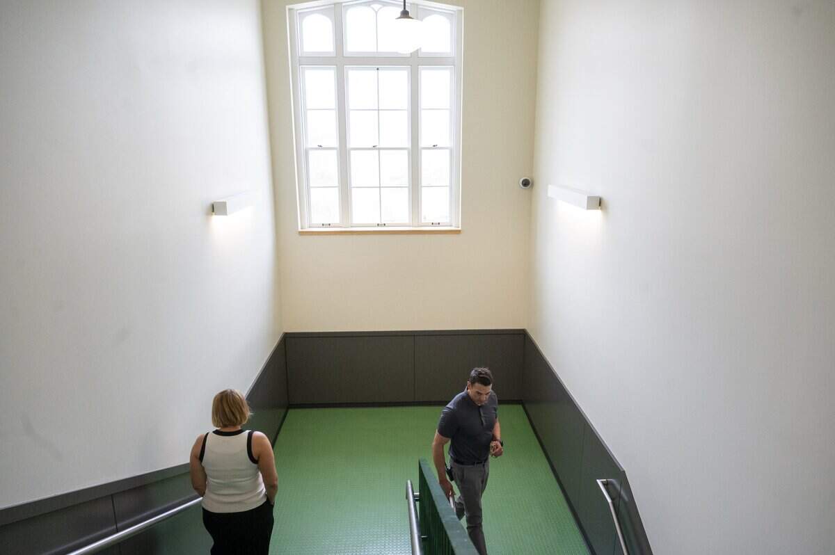 Original windows from the over 100-year-old building let light into a stairwell of the newly renovated Oakland Secondary School on Thursday, Sept. 4, 2025, in Tacoma, Wash. Kathryn McCarthy, left, the district's spokesperson, and principal Shaun Martin, lead a tour of the space.