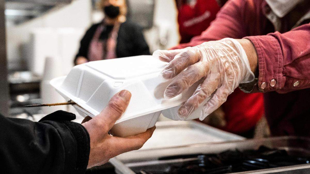Volunteers serve warm meals to unhoused people at the Tacoma Rescue Mission on Thursday, April 14, 2022.