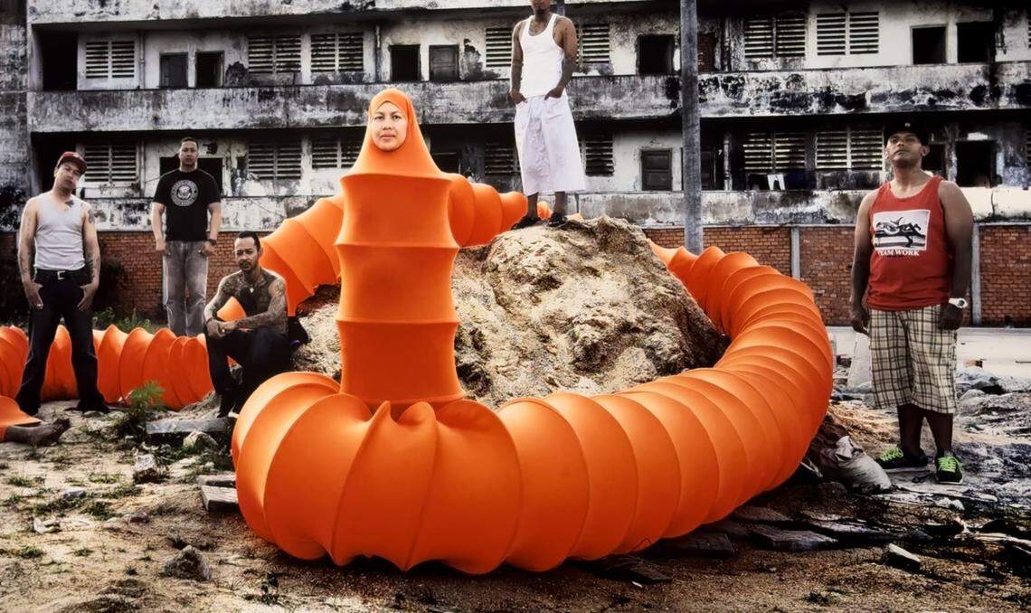 “The Exiles” by Dylan Maddux shows Anida Yoeu Ali as “The Buddhist Bug” with Cambodian Americans who have been deported to Cambodia.