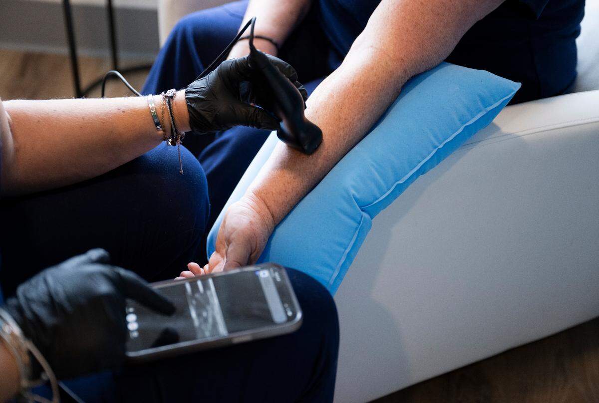 Registered nurse Laura Ude demonstrates the ultrasound technology used for “tough sticks” at Revive Drip, on Monday, April 8, 2024, in Gig Harbor.