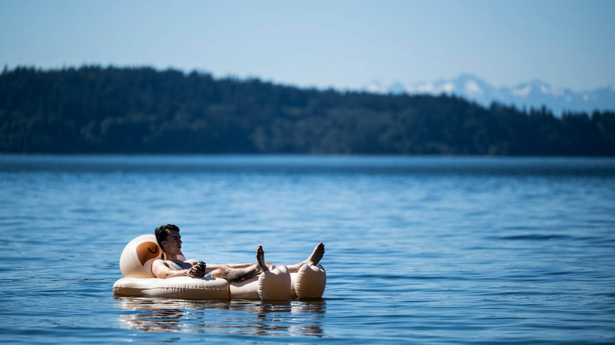 A man floats in a raft at Sunnyside Beach in Steilacoom, Wash. on Sunday, June 26, 2022.