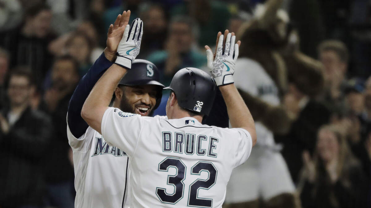 Seattle Mariners’ Jay Bruce (32) is greeted by Domingo Santana, left, after Santana scored on a Bruce’s home run during the seventh inning of a baseball game against the Los Angeles Angels, Monday, April 1, 2019, in Seattle.