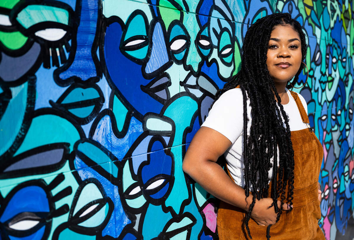 Local artist Tiffanny Hammonds poses for a portrait in front of a mural she painted on the side of the new Tacoma Housing Authority building at Earnest Brazill Street and Martin Luther King Jr. Way in Tacoma, on Oct. 6, 2022.
