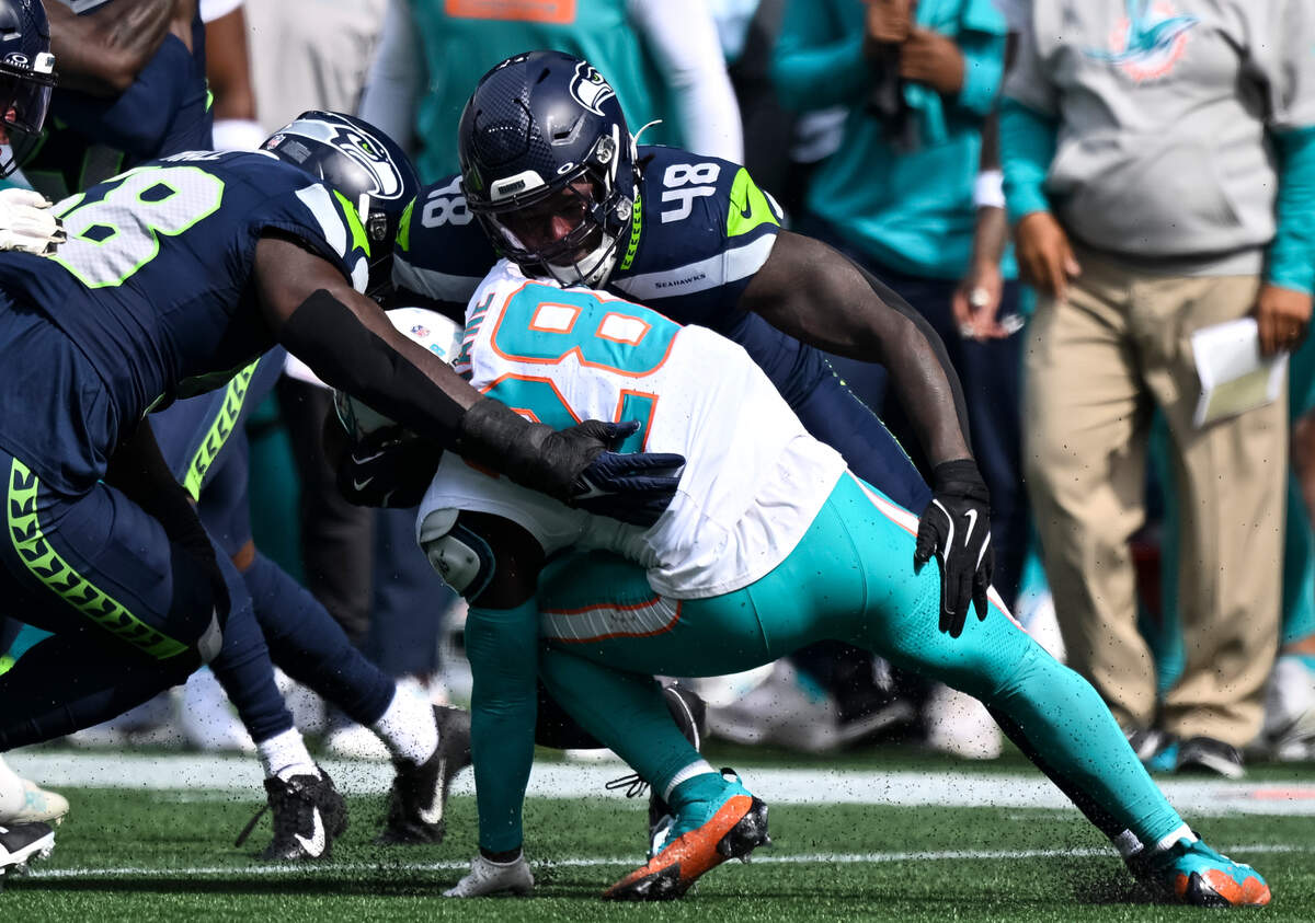 Seattle Seahawks linebacker Tyrice Knight (48) wraps up Miami Dolphins running back De’Von Achane (28) during the first quarter of the game at Lumen Field, on Sunday, Sept. 22, 2024, in Seattle, Wash.