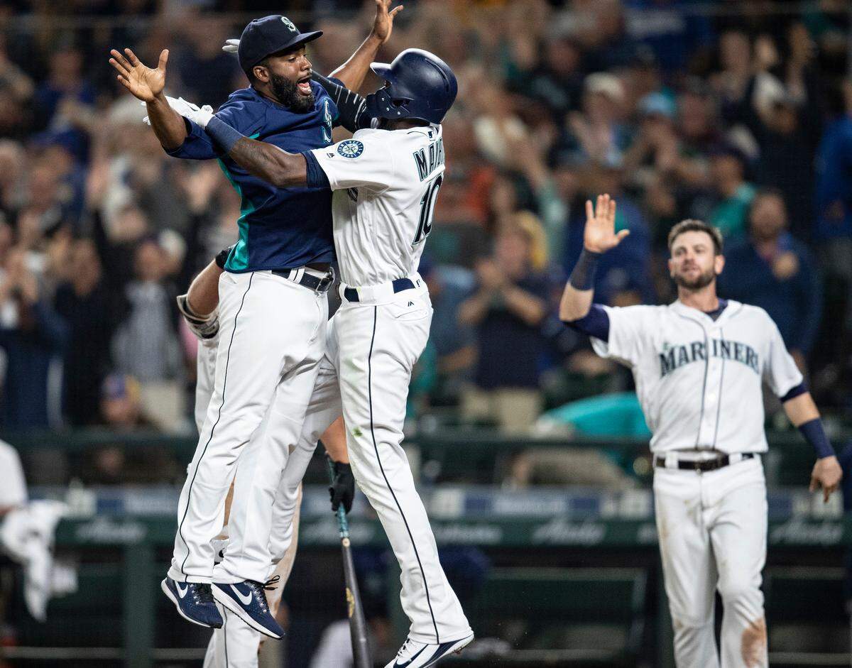 Seattle Mariners’ Denard Span, left, Cameron Maybin and Mitch Haniger celebrate after a baseball game against the Los Angeles Dodgers, Saturday, Aug. 18, 2018, in Seattle. The Mariners won 5-4 in 10 innings, when Maybin scored on a balk by Los Angeles Dodgers relief pitcher Dylan Floro. (AP Photo/Stephen Brashear)
