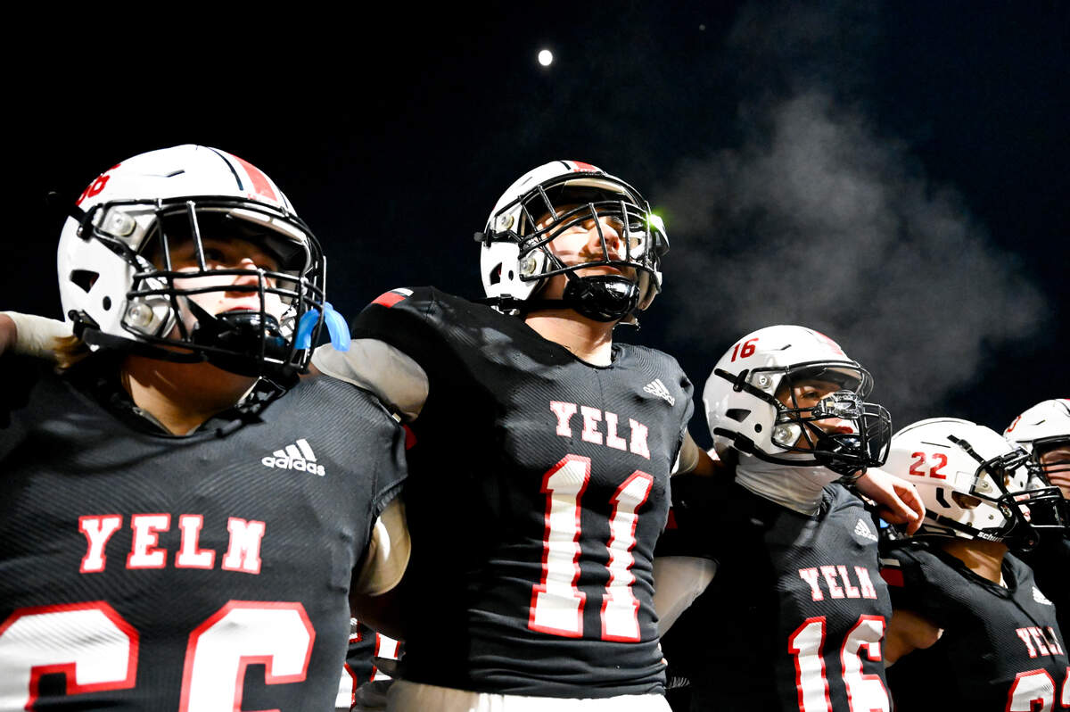Yelm locks arms and sings “Take me home, country roads” after their 7-0 victory against Eastside Catholic in the 3A semifinal state game at Art Crate Field, Saturday, Nov. 25, 2023, in Spanaway, Wash.