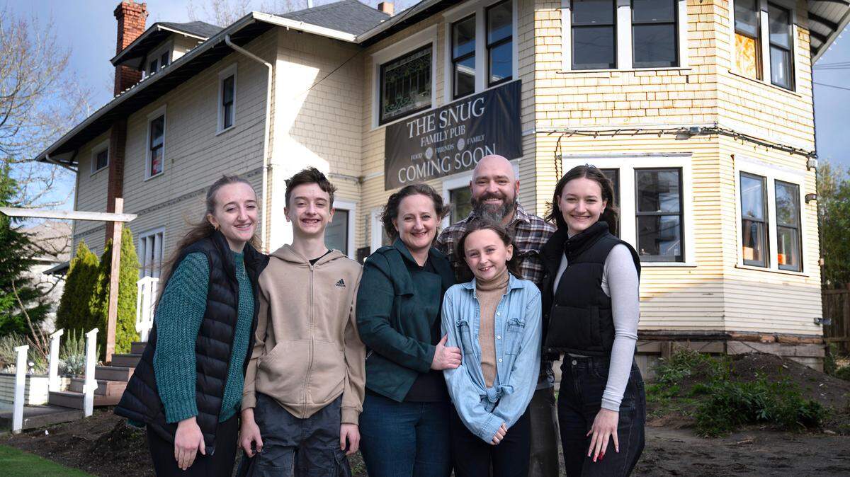 Andrea and Paul Evans with their children (from left) Keira, Declan, Brinna and Fiona outside the new location for The Snug Family Pub in the Proctor District of Tacoma, Washington, on Wednesday, Dec. 18, 2024.
