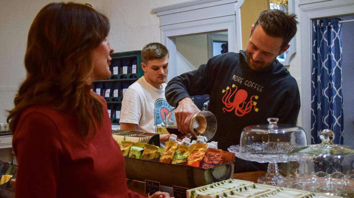 Luke Wilbanks prepares a pour-over coffee at his new cafe in Buckley, Washington, with his wife Tanya Wilbanks and operations manager Hunter March on Nov. 12, 2021. Anchor House Coffee Roasters offers house-roasted beans and a full range of coffee drinks, with a portion of proceeds benefiting anti-trafficking programs.