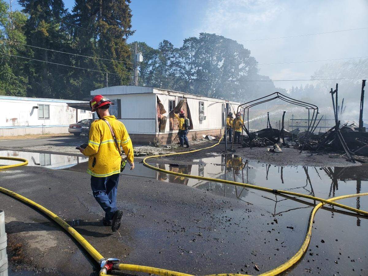 FILE: West Pierce Fire & Rescue crews survey the damage at a mobile home park damaged by a brush fire Friday, Aug. 4, 2023