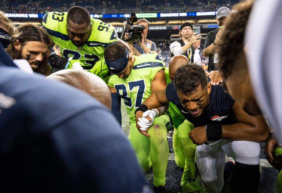 Denver Broncos quarterback Russell Wilson (3) leads a prayer on the field with his former teammates after the Seattle Seahawks beat the Broncos 17-16 in an NFL game on Monday, Sept. 12, 2022, at Lumen Field in Seattle.