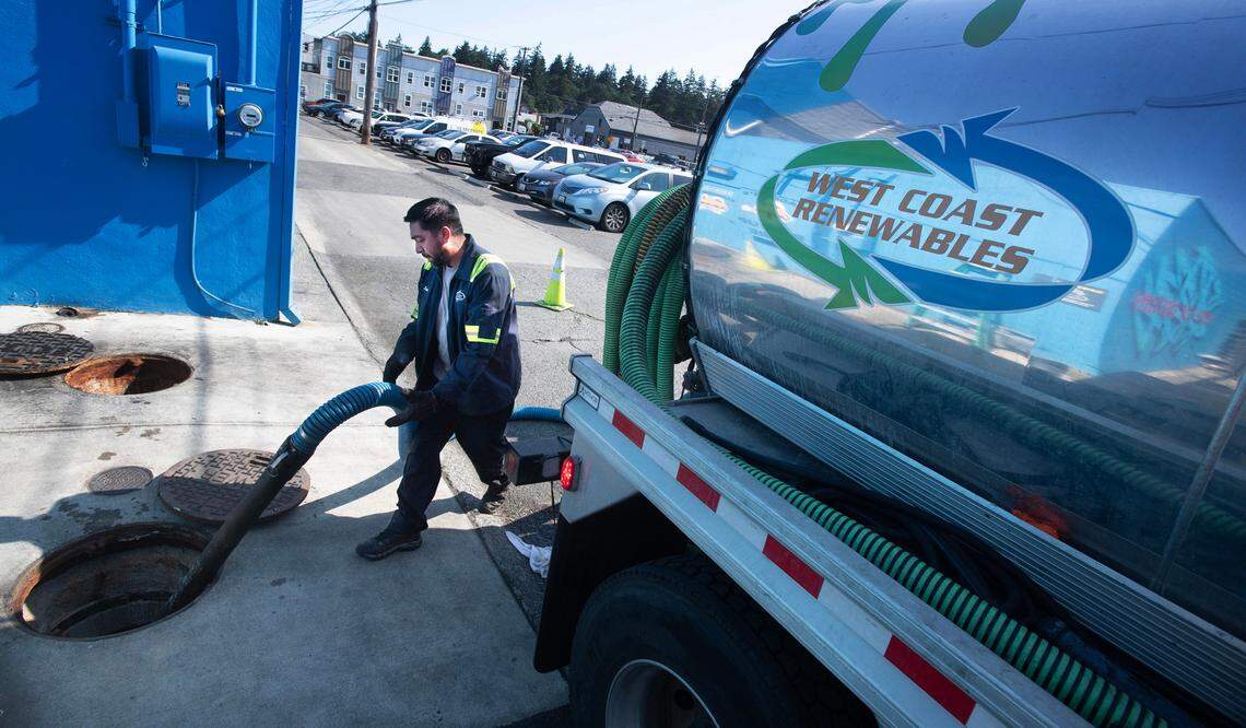 Grease trap cleaner Juan Parada empties the large concrete gravity grease interceptors beneath the street behind Edison Square in Tacoma in July 2024. City council hopes a new educational flyer will help prospective restaurants know whether they would need to upgrade their FOG devices before leasing or buying a space.