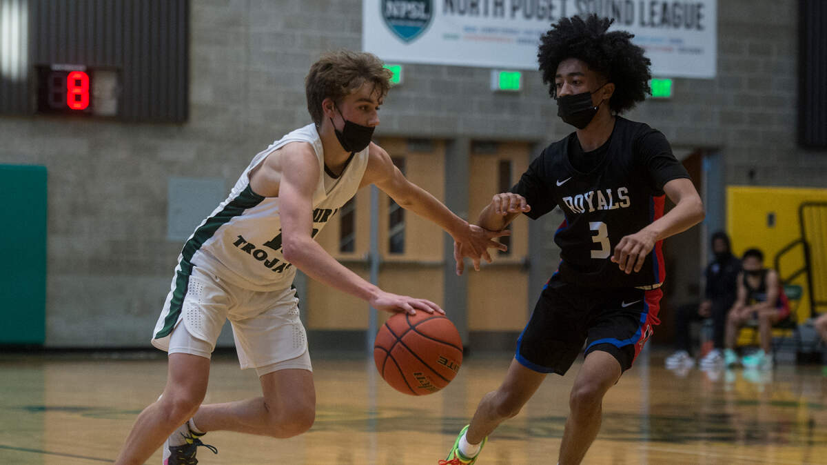 Auburn High School guard Kaden Hansen brings the ball up the court as Kent Meridian guard Jordan Smalls defends in a Class 3A North Puget Sound League boys basketball game on Tuesday, June 15, 2021 in Auburn, Wash.