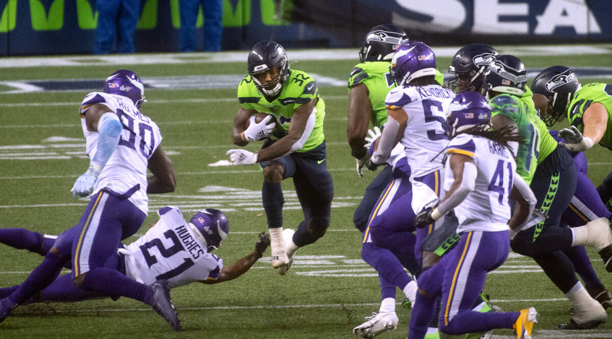 Seattle Seahawks running back Chris Carson leaps past Minnesota Vikings cornerback Mike Hughes during Sunday night’s NFL football game at Centurylink Field in Seattle, Washington, on Sunday, Oct. 11, 2020.
