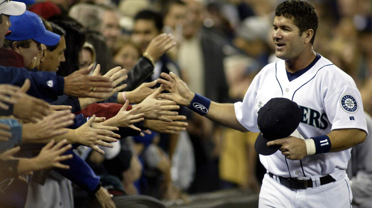 Seattle Mariners Edgar Martinez high fives Mariner fans as he runs the track surrounding the infield during Edgar Martinez Day on Saturday, Oct. 2, 2004 in Seattle. (AP Photo/Jim Bryant)