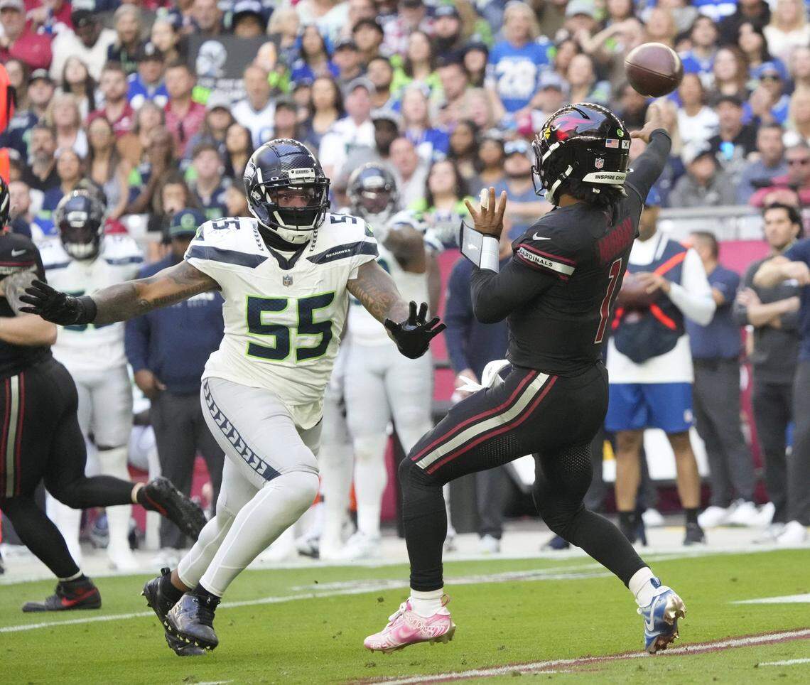 Arizona Cardinals quarterback Kyler Murray (1) throws while pressured by Seattle Seahawks defensive end Dre'Mont Jones (55) during the first quarter at State Farm Stadium in Glendale on Dec. 8, 2024.