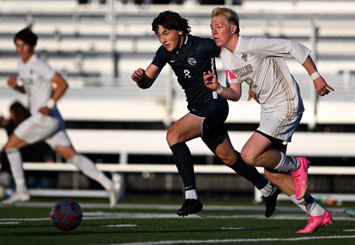 Bellarmine Prep defender Rory O’Reilly and Puyallup midfielder Zack Robertson (22) chase down the ball during the match at Bellarmine Preparatory School, on Tuesday, April 16, 2024, in Tacoma, Wash.