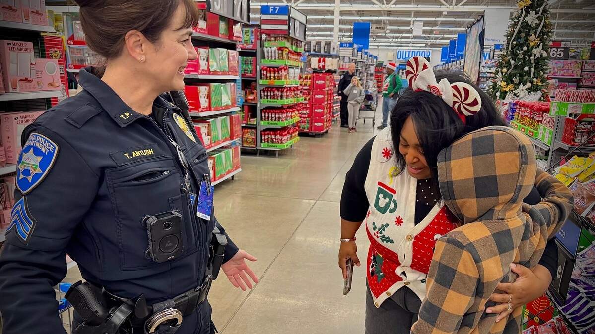 Kellan Hughes, 10, gets a hug from Washington State Patrol community engagement liaison April Hunter as Hughes’ shopping helper, Tacoma Police Sergeant Teresa Antush looks on. The three were at the annual Shop With A Tacoma Cop event at Walmart in Tacoma Saturday, Dec. 14, 2024.