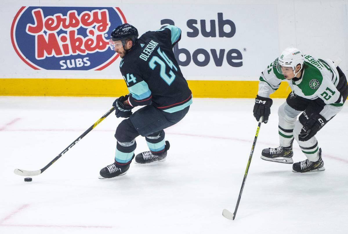 Seattle Kraken defenseman Jamie Oleksiak (24) moves the puck down the ice as Dallas Stars left wing Jason Robertson (21) defends during the second period of game four of the second round of the 2023 Stanley Cup Playoffs in Seattle, Wash. on May 9, 2023.