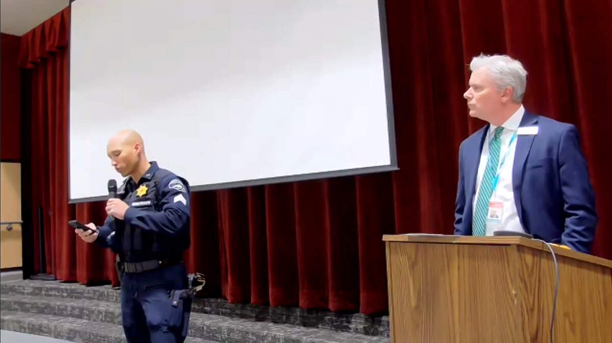 Sergeant Darren Moss, from the Pierce County Sheriff’s Department, reads a medical examiner’s report on the death of Lenyia Swansey Faafiti, a sixth grader at Ford Middle School, as Franklin Pierce School District Superintendent Dr. Lance Goodpaster watches from the podium during a work session on school safety at Central Avenue Elementary School on Tuesday, May 24, 2022, in Tacoma, Wash. After an altercation with another student earlier in the week, the 11-year-old had no signs of injury, according a statement from the Pierce County Medical Examiner’s Office read Tuesday night at a meeting called to address school safety in the Franklin Pierce School District.
