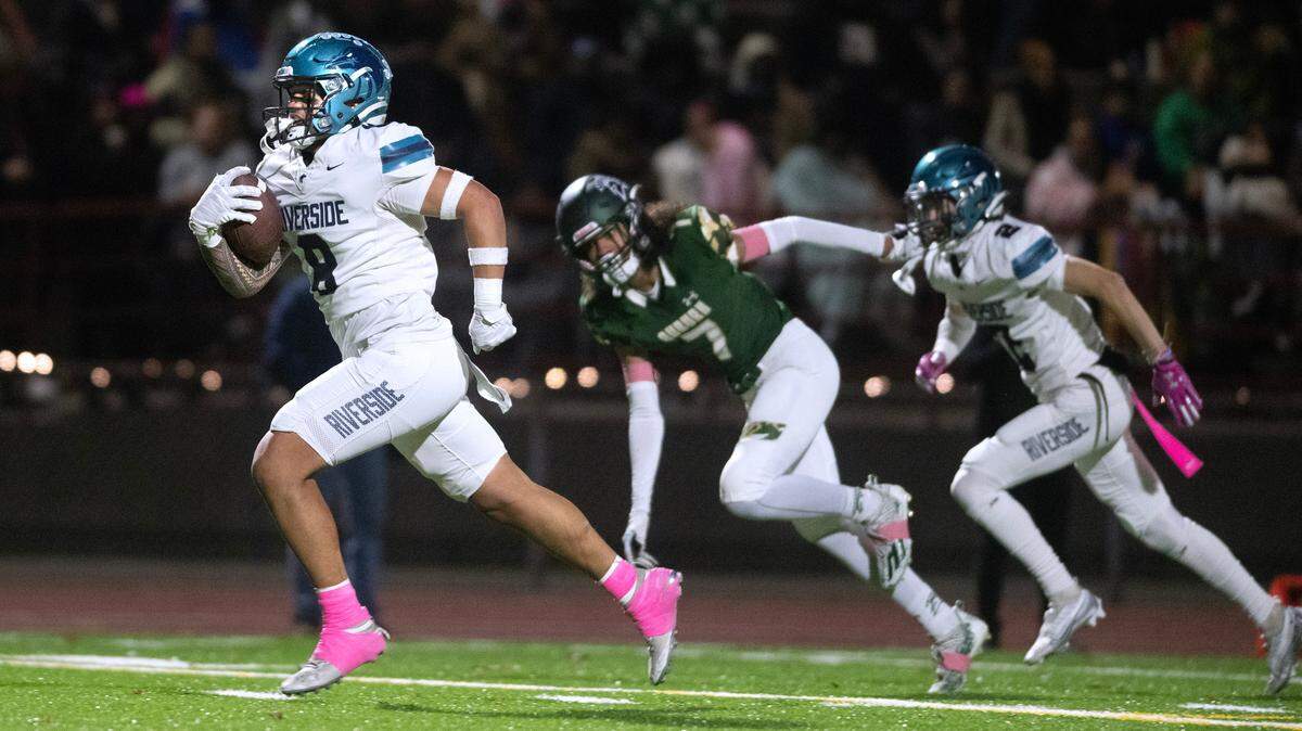 Auburn Riverside running back Thyrou Umi-Tuato’o breaks away from Auburn defensive back Izear Ferguson for a touchdown during Friday night’s 3A NPSL championship game at Auburn Memorial Stadium in Auburn, Washington, on Oct. 27, 2023. Auburn Riverside won the game, 41-14.