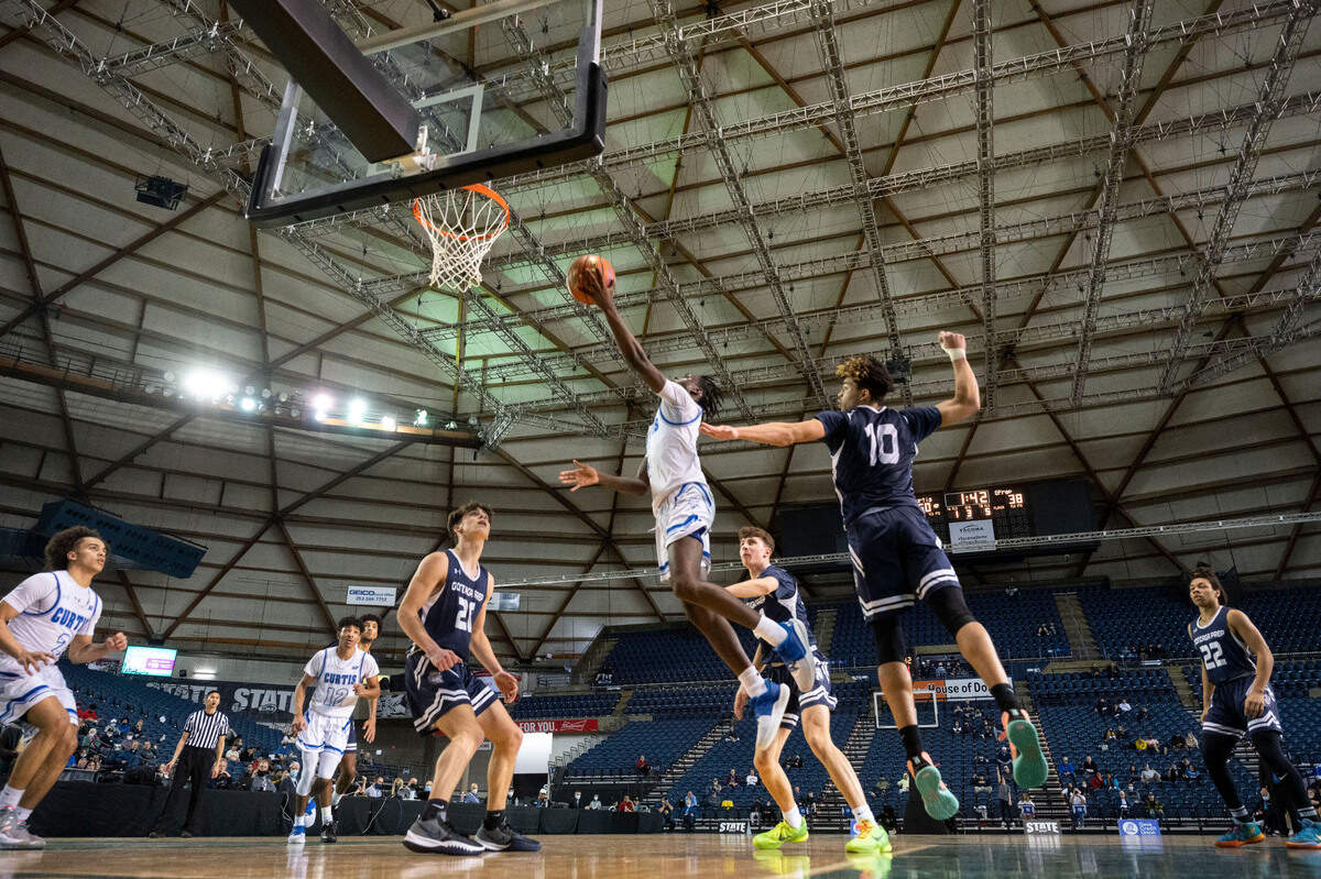 Curtis guard Zoom Diallo (5) goes in for a layup as Gonzaga Prep forward Jamil Miller (10) defends during the third quarter of a Class 4A quarterfinal state tournament game on Thursday, March 3, 2022, at the Tacoma Dome, in Tacoma, Wash.