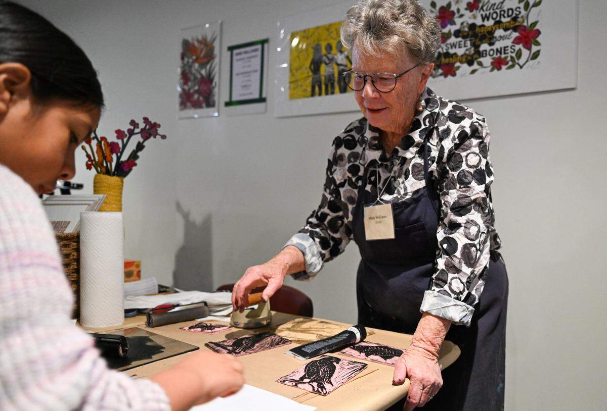Artist Mimi Williams, right, helps make a linoprint during the Wayzgoose printmaking festival at the Tacoma Public Library, on Friday, May 2, 2025, in Tacoma.