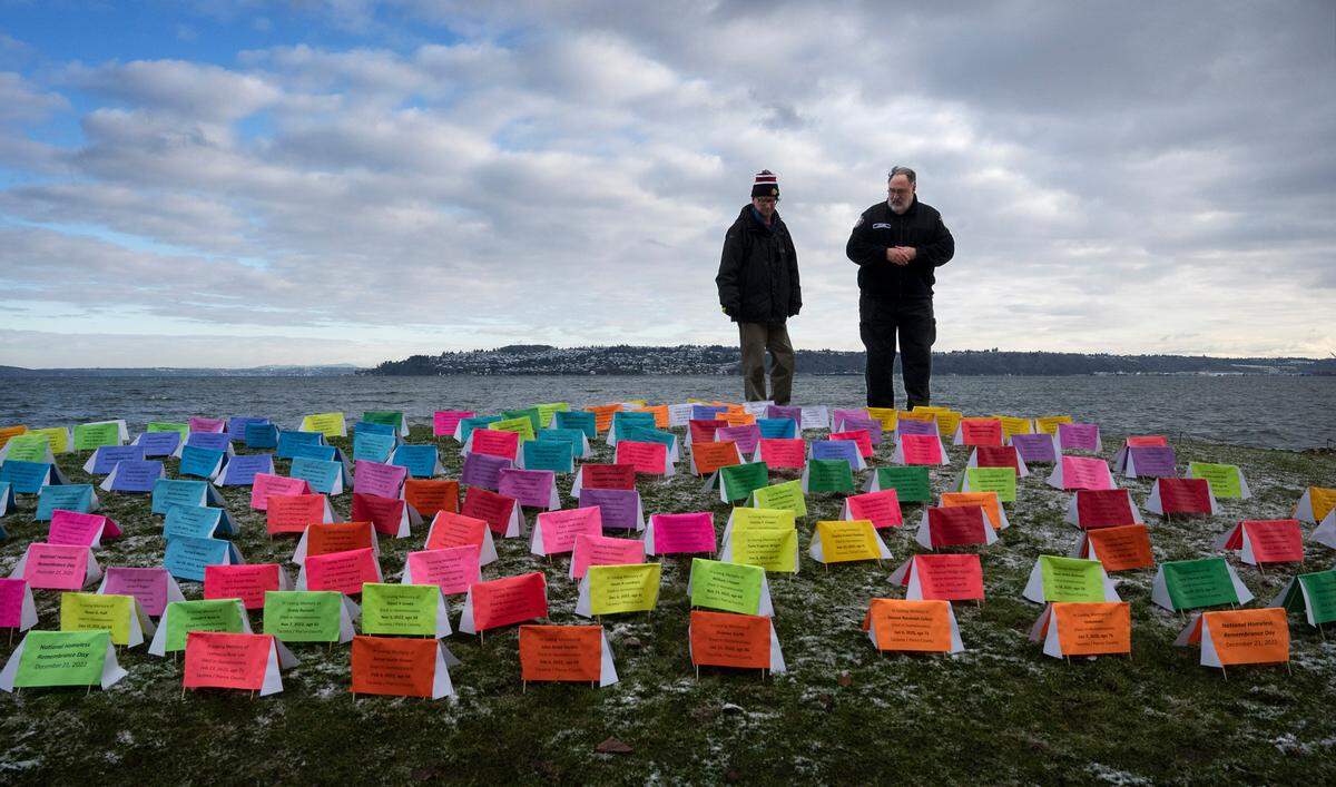 Homeless advocates Richard Dorsett (left) and Ed Jacobs look over the memorial at Judge Jack Tanner Park in Tacoma, Washington, on Wednesday, Dec. 21, 2022. Each of the 167 tents represents a homeless person who died in Pierce County this year.