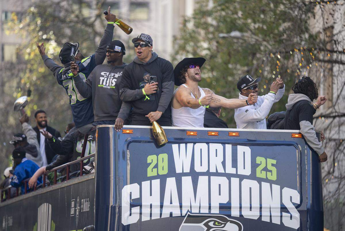 Seahawks players, including running backs Cam Akers and Zach Charbonnet and tight end AJ Barner celebrate during the Super Bowl parade on Wednesday, Feb. 11, 2026, in Seattle.
