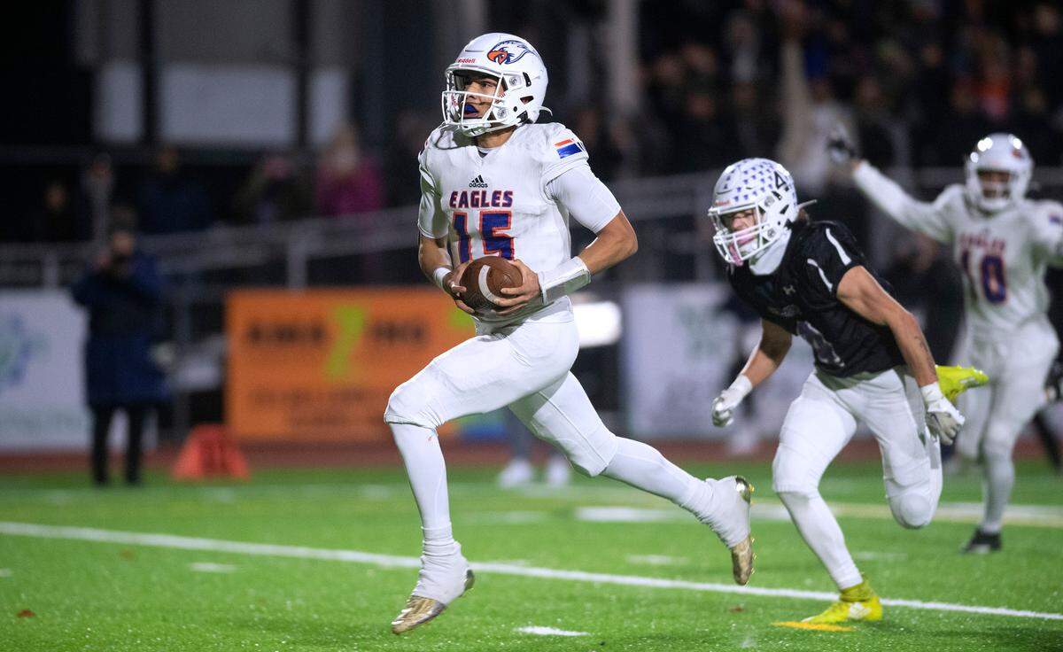 Graham-Kapowsin quarterback Daveon Superales breaks loose on front of Sumner defensive back Dylan Coffey for the game-winning touchdown late in Friday night’s 4A football state quarterfinal game at Sunset Chev Stadium in Sumner, Washington, Nov. 18, 2022. Graham-Kapowsin won the game, 28-21.