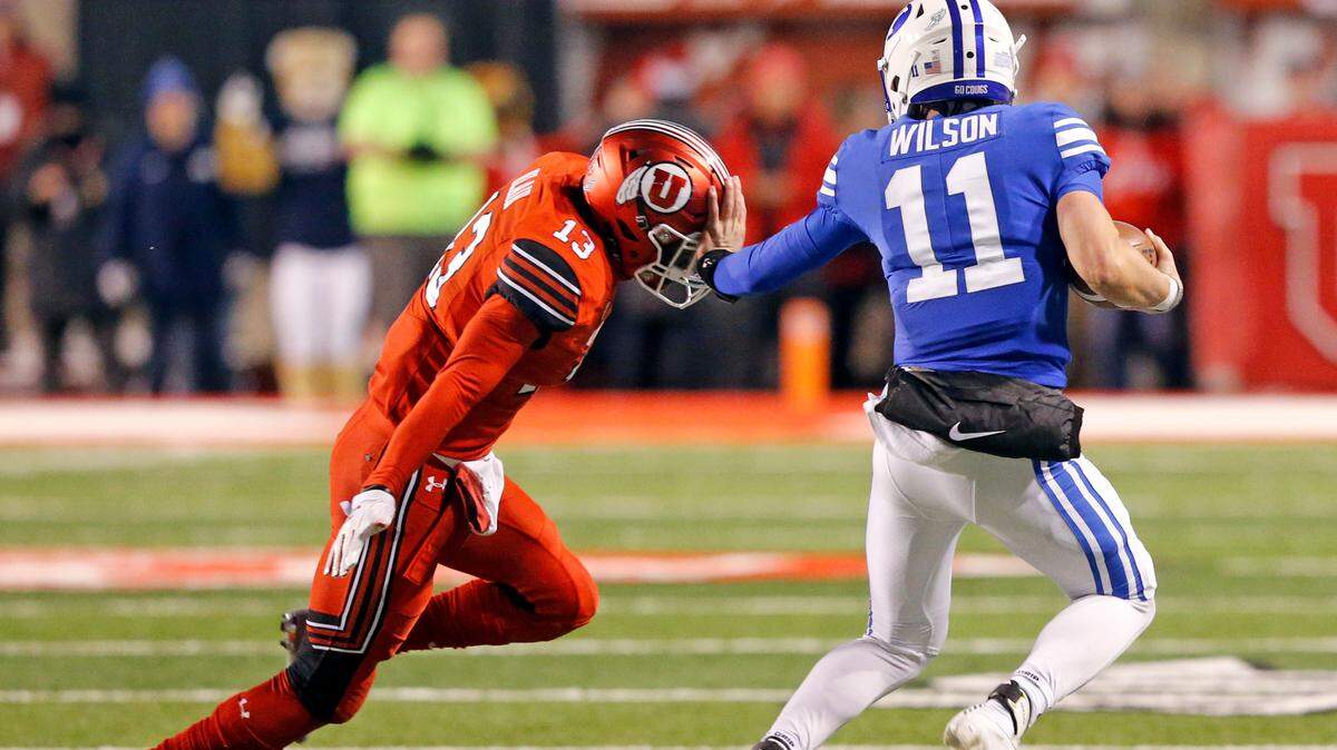 BYU quarterback Zach Wilson (11) stiff arms Utah defensive back Marquise Blair (13) as he carries the ball in the first half during an NCAA college football game Saturday, Nov. 24, 2018, in Salt Lake City. (AP Photo/Rick Bowmer)