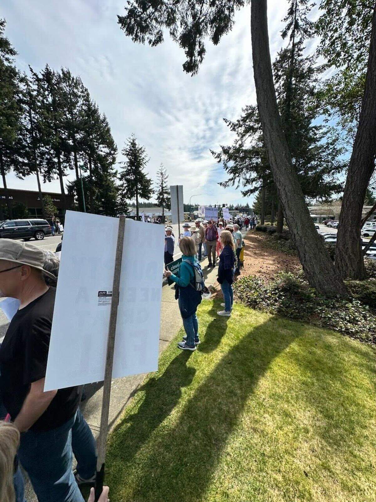 Residents protest policies led by Trump and Musk Saturday afternoon, April 5, 2025, in Gig Harbor, Wash.