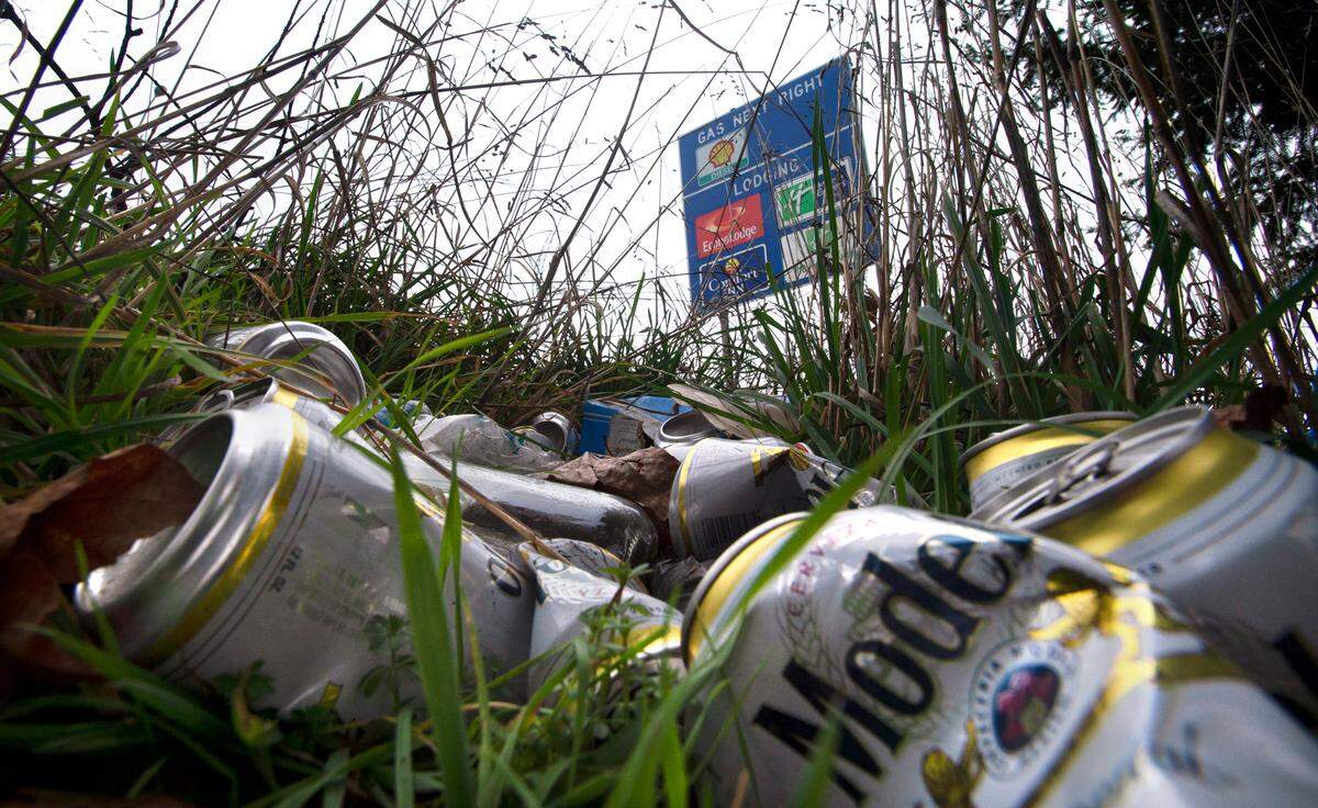 A pile of beer cans lies in the grass along Interstate 5 through Tacoma, Washington, on Wednesday, Feb. 17, 2021.