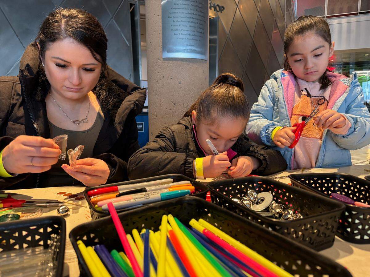 Janett Villegas and her twin daughters Amy (middle) and Ariana Balderas make “trash bugs” Saturday, Nov. 16, 2024 at the Museum of Glass in Tacoma.
