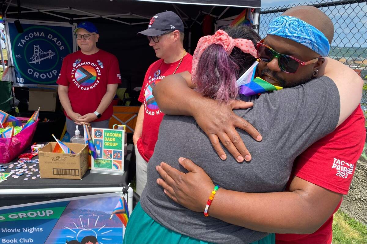 Jessie Keating of Tacoma gets a hug from Thomas Barcous at the Tacoma Pride festival Saturday afternoon. Barcous and his group, Tacoma Dads, were staffing a hug booth. “I just haven’t been around a dad in a long time,” Keating said.