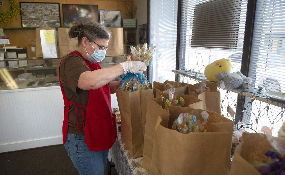 Liz Beaupid of Tacoma prepares phone-in orders for pick at Johnson Candy in Tacoma on Wednesday, April 8, 2020.