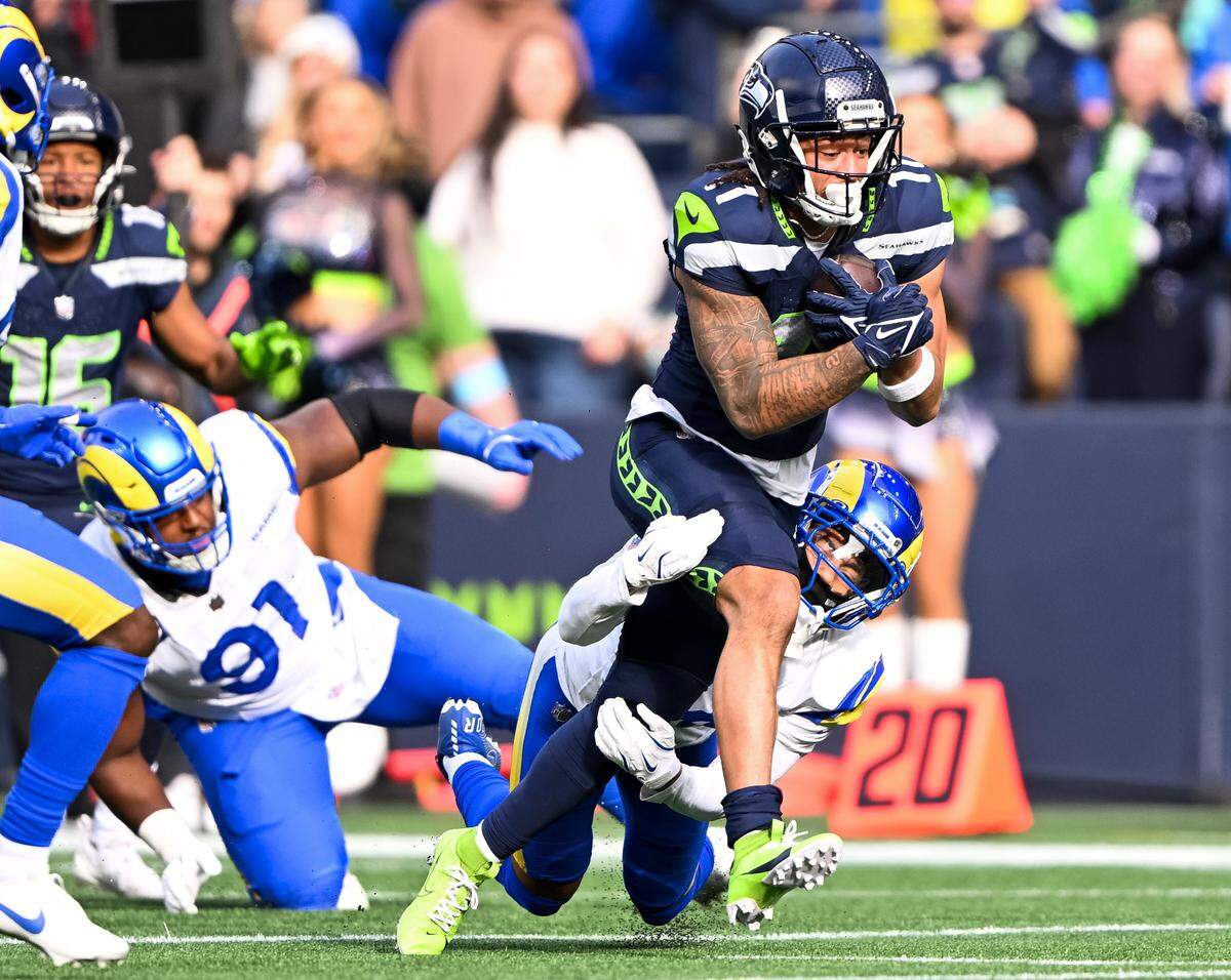 Seattle Seahawks wide receiver Jaxon Smith-Njigba (11) picks up yards after the catch with Los Angeles Rams cornerback Cobie Durant (14) in tow during the first quarter of the game at Lumen Field, on Sunday, Nov. 3, 2024 in Seattle, Wash.