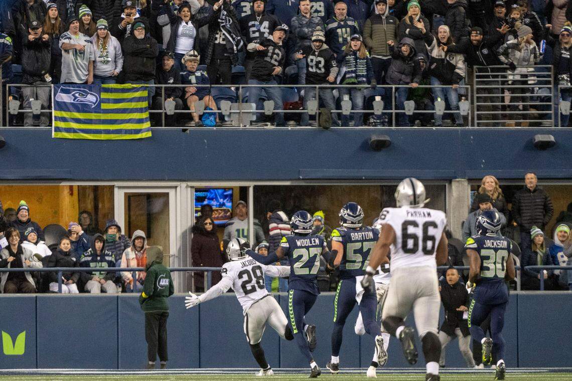 Fans react as Las Vegas Raiders running back Josh Jacobs (28) runs into the endzone for the game-winning touchdown in overtime of an NFL game on Sunday, Nov. 27, 2022, at Lumen Field in Seattle. Las Vegas beat Seattle, 40-34.