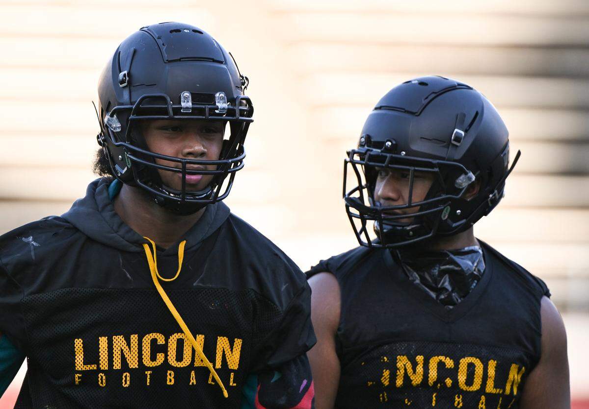 Brothers Dre Sio Fetaui and Kelly Sio-Fetaui walk off the field during practice at Lincoln High School, Friday, Aug. 18, 2023, in Tacoma, Wash.