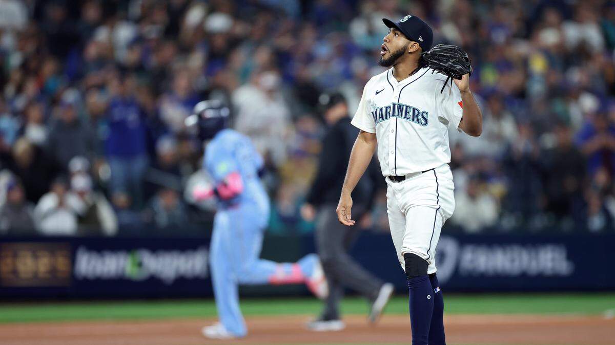 SEATTLE, WASHINGTON - OCTOBER 16: Eduard Bazardo #83 of the Seattle Mariners reacts as Vladimir Guerrero Jr. #27 of the Toronto Blue Jays rounds the bases after hitting a solo home run during the seventh inning in game four of the American League Championship Series at T-Mobile Park on October 16, 2025 in Seattle, Washington. (Photo by Steph Chambers/Getty Images)