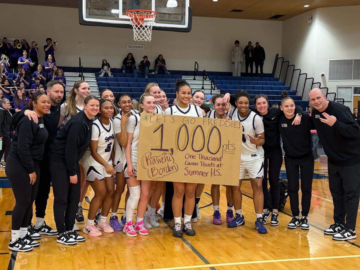 Sumner guard Kawehi Borden poses with teammates in celebration of joining the 1,000-point career scoring club after a 52-30 win over Olympia in the 4A SPSL championship game on Feb. 7, 2026, at Tacoma Community College.